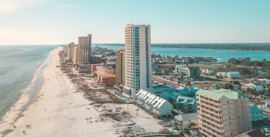 Aerial view of a beach with waves, surrounded by buildings