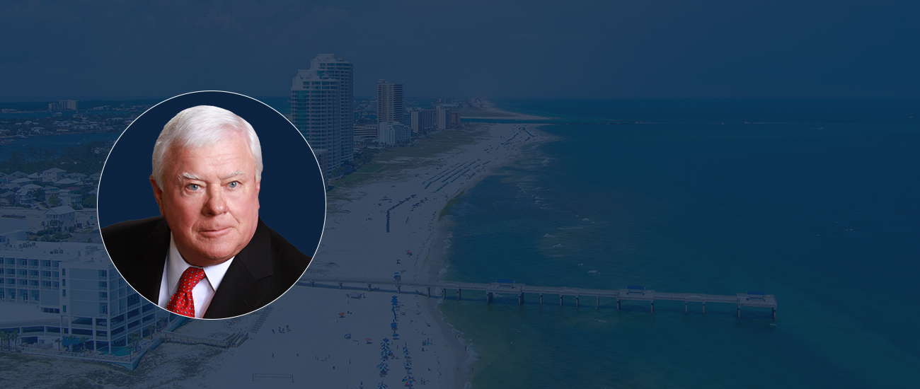 Attorney Jule Herbert with an Aerial view of a beach with waves, surrounded by buildings in the background
